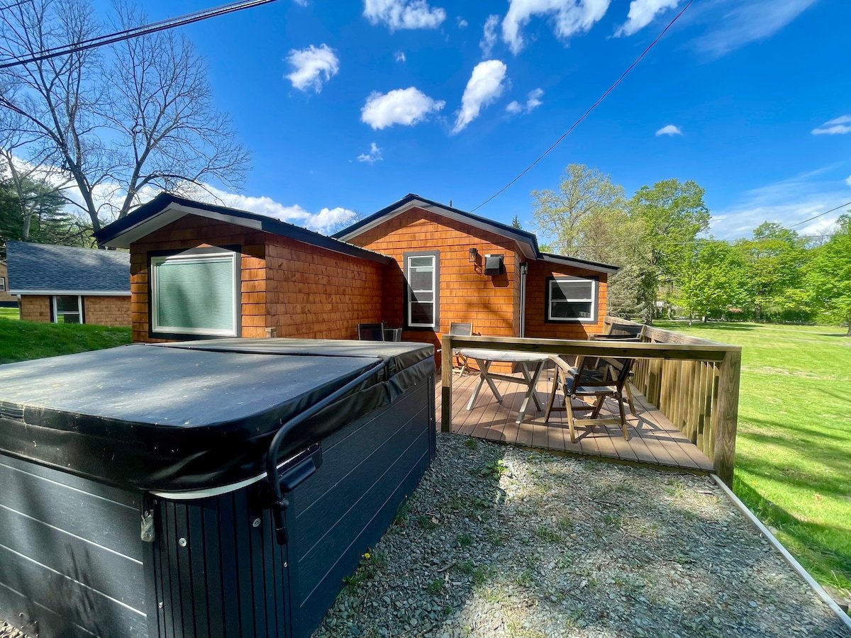 Deck and tub surrounded by trees at Cove King Bed Escape
