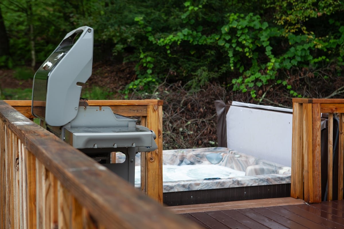 Private hot tub and barbecue grill on Cove deck with a glass of rosé